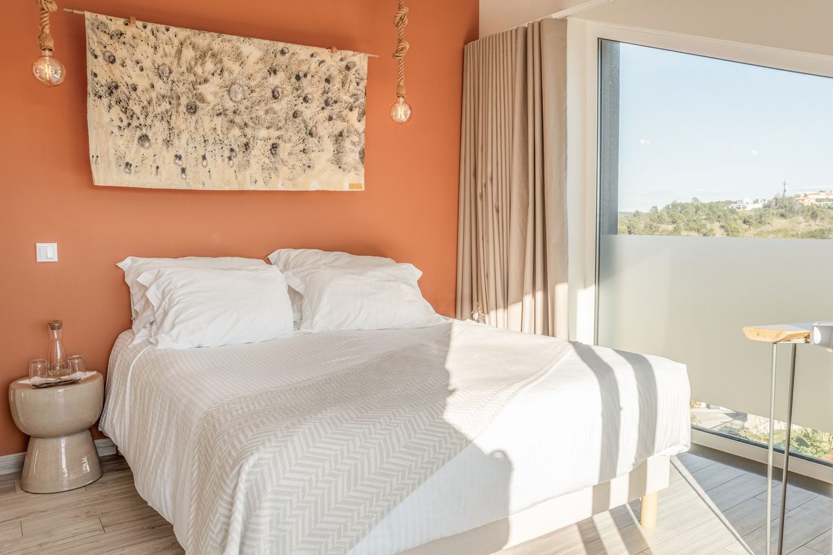 Double bed with artwork above it and the window alongside