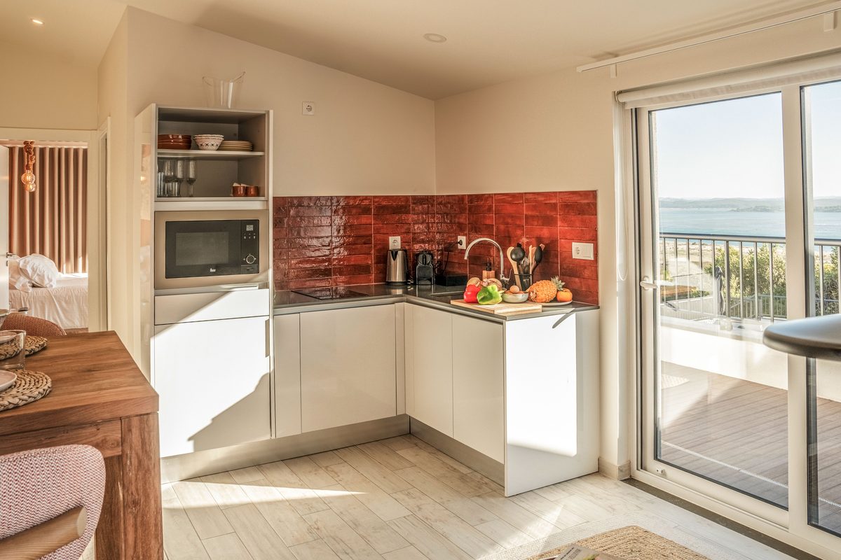 Kitchen with a red tiled splashback and the terrace door open