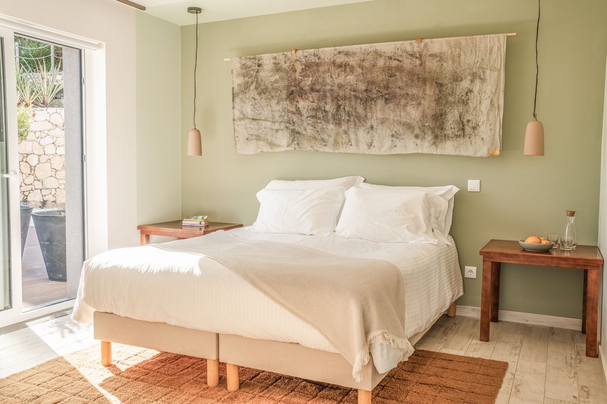 Double bed with a bark artwork above and a side table