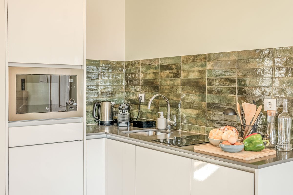 Kitchen with a green tiled splashback