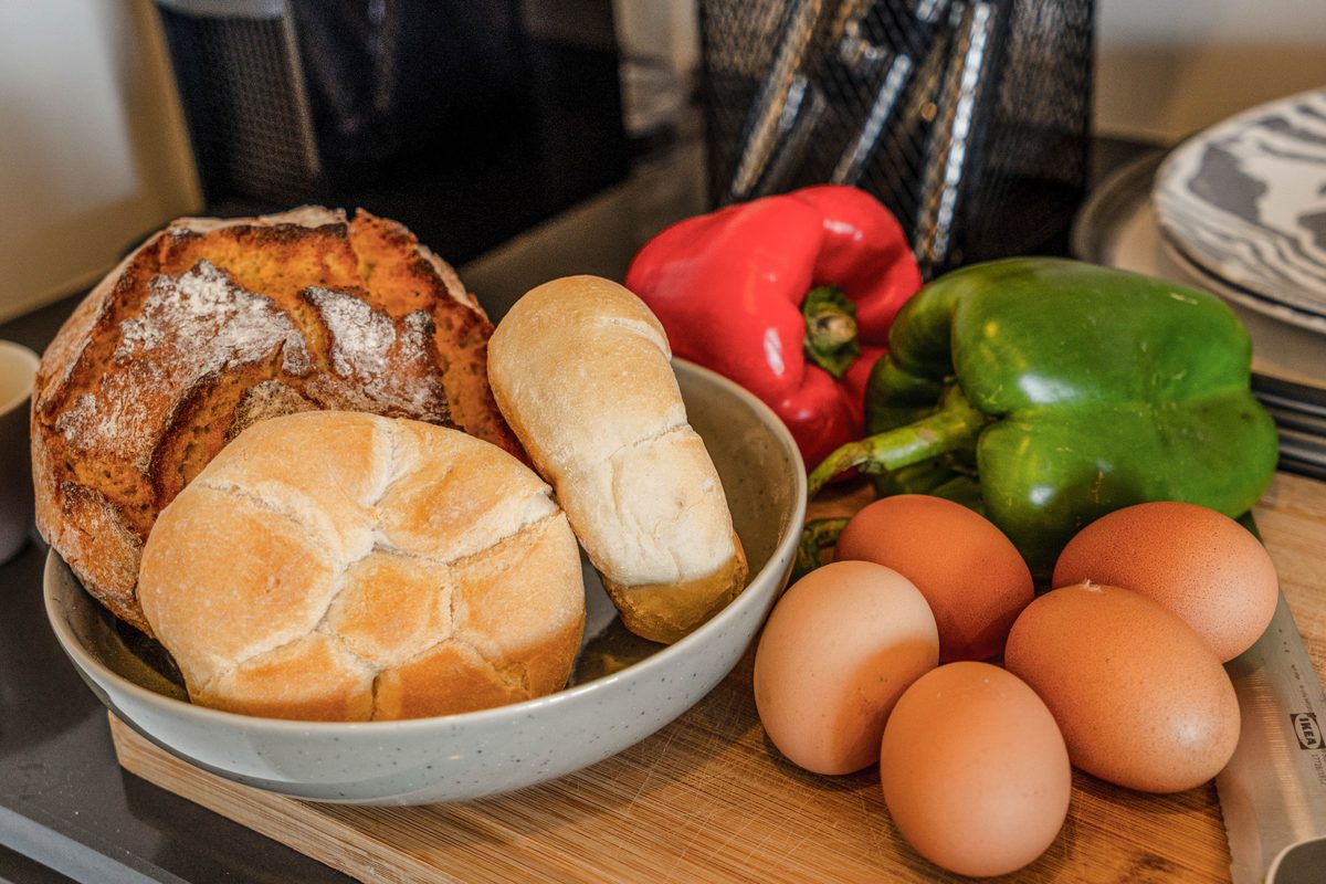 Bread, eggs and peppers in a bowl on the kitchen counter
