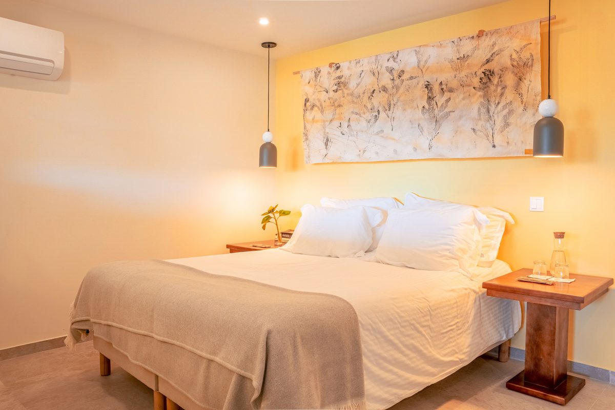 Double bed below a wide framed artwork, lamps either side